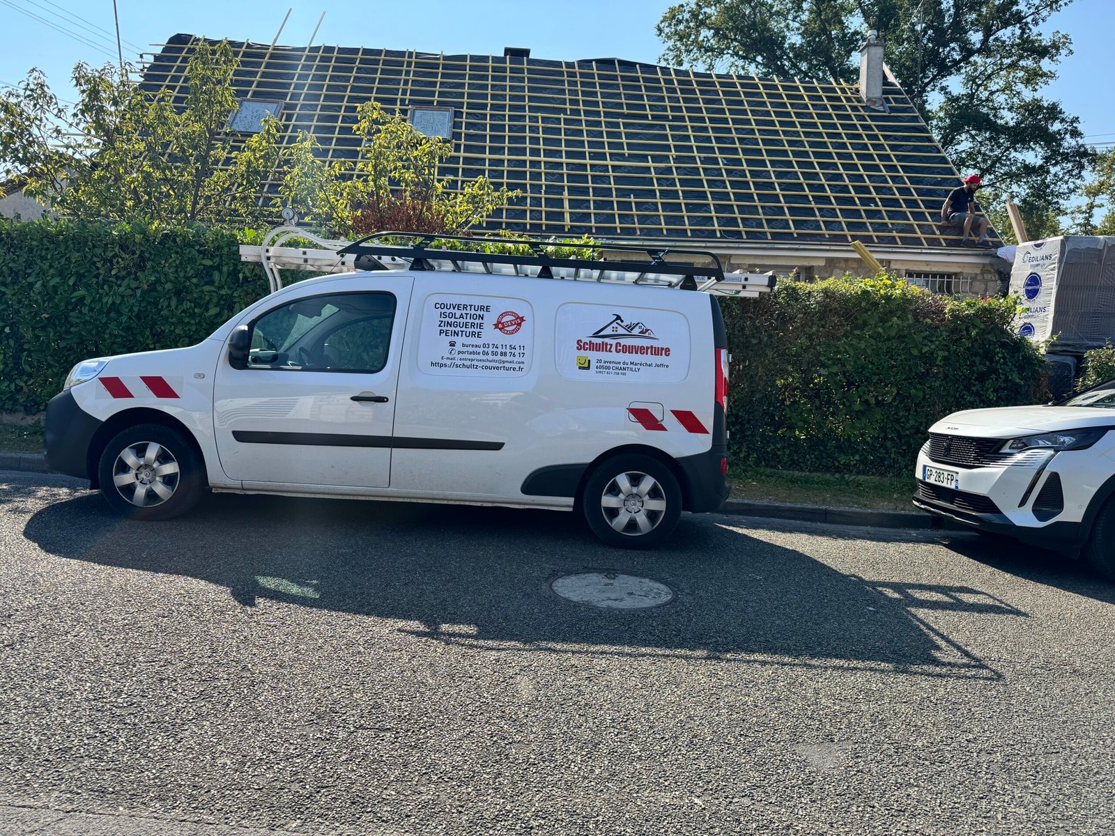 Le véhicule de Schultz Couverture devant un chantier de réfection de toiture à Chantilly